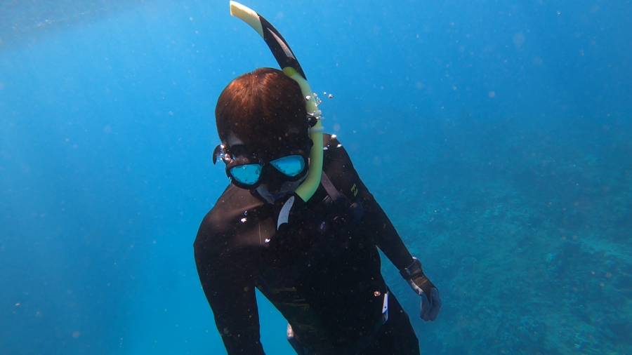 Freediver suspended in clear blue open water